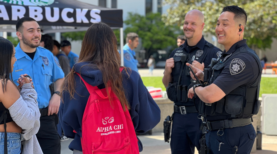 Two police officers standing outside of a police vehicle looking at maps during a drill