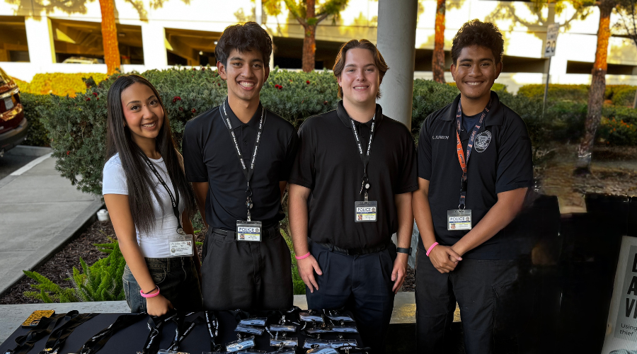Four student workers standing shoulder to shoulder smiling.