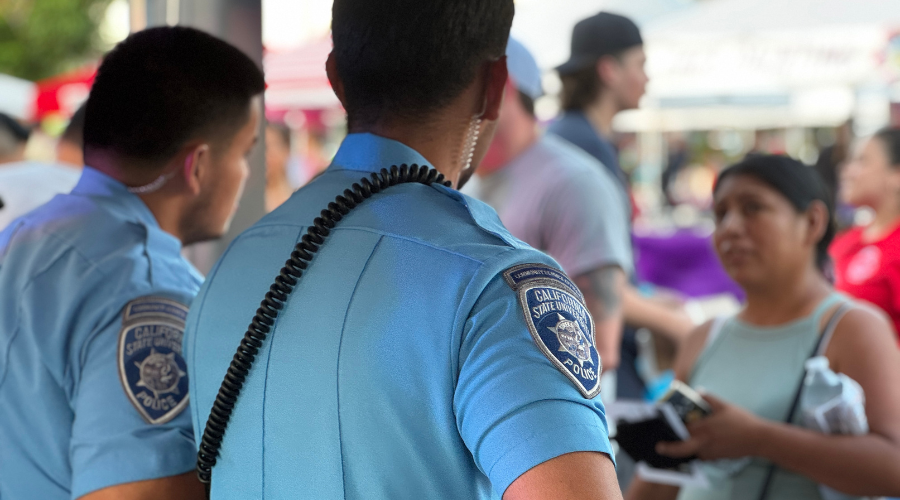 Two student community services officers talking to a community member